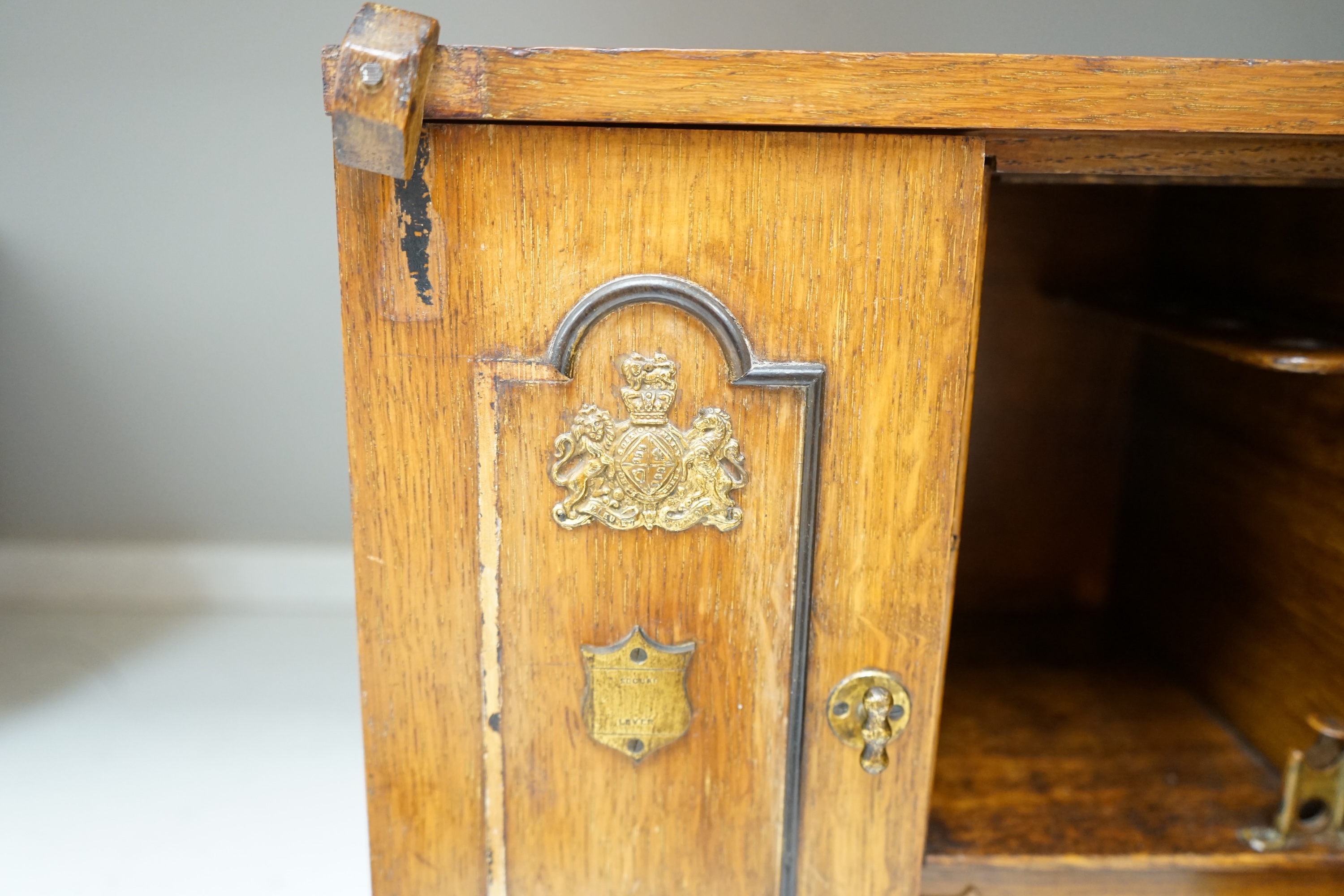 A Victorian oak cigar cabinet modelled as a safe, with brass coat of arms mounts, 30cm wide, 31cm high. Condition - fair